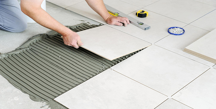 hands worker are laying ceramic tile floor copy