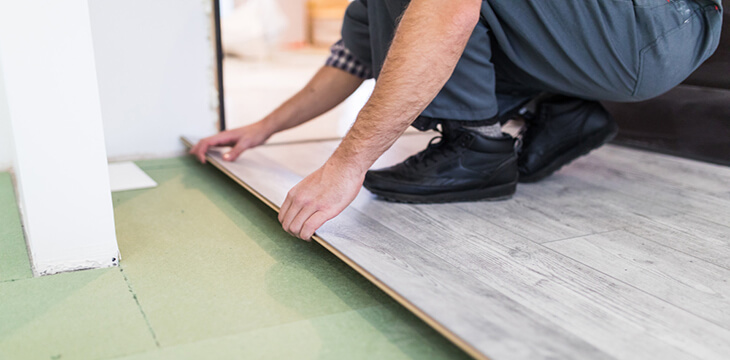 worker processing floor with laminated flooring boards copy